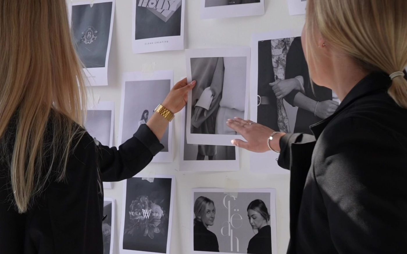 Clëah Creative team planning a shoot around a wall of printed images