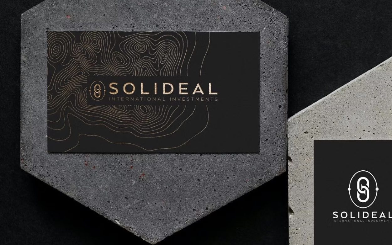 Solideal International Investments business cards in gold foil on concrete