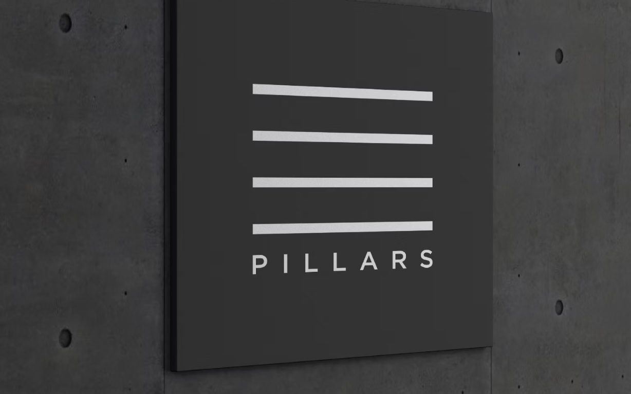 Pillars signage mounted on a concrete wall